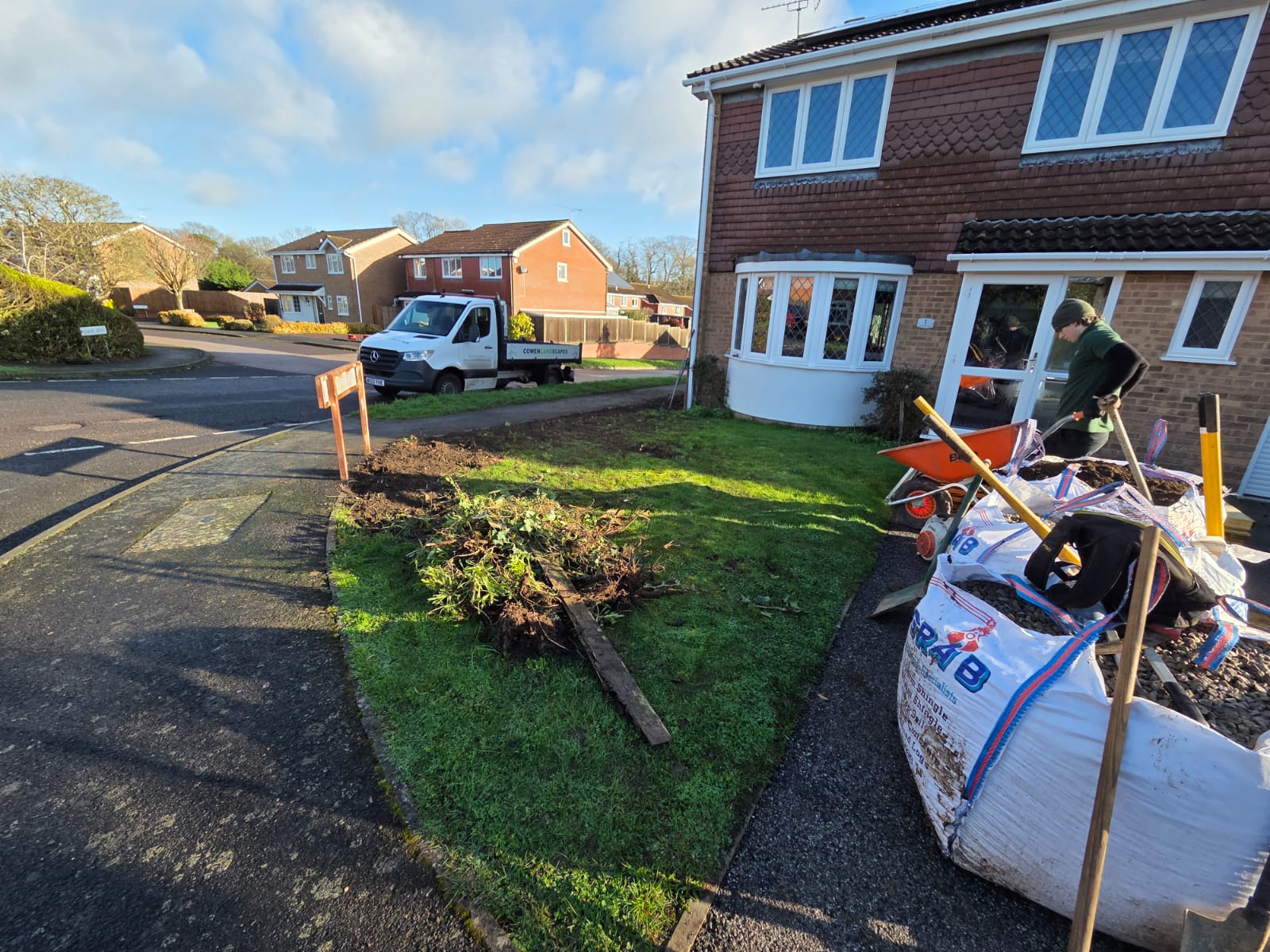 Front garden clearance underway with removed vegetation and landscaping equipment